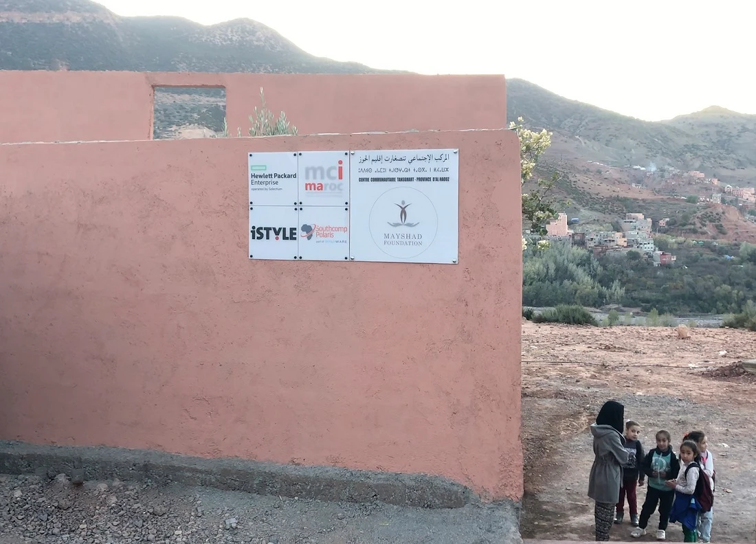 a view of the outside of the Community Center, showing logos of Midis affiliate companies on the wall