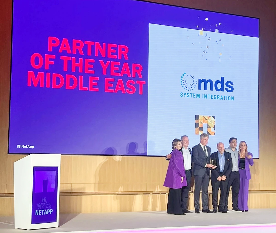 six people are seen on a presentation stage with Partner of the Year spelt out in large text on a screen behind them