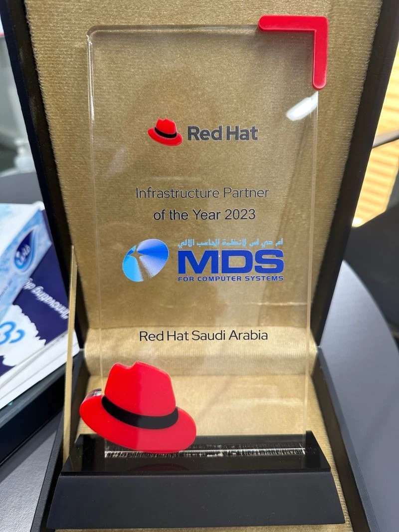 un trophée en verre dans une boîte de présentation avec une photo de chapeau rouge bien visible