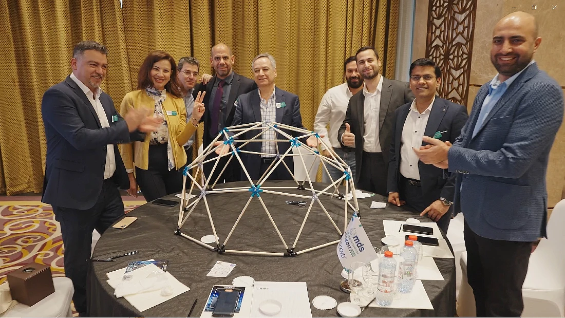 a group of people are seen around a table after completing a task to build a model geometric structure