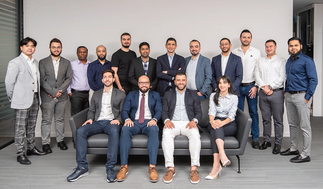 seize personnes sur une photo de groupe dont quatre sont assises devant le groupe.