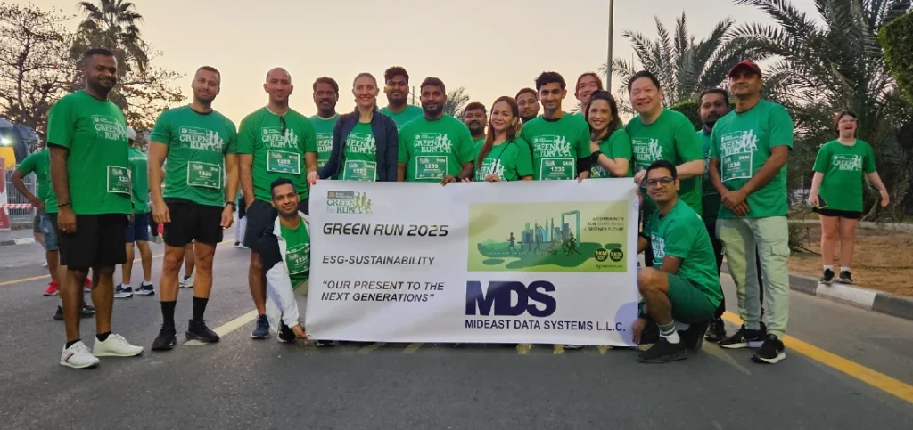 people in green t-shirts are gathered at the start of a fun run