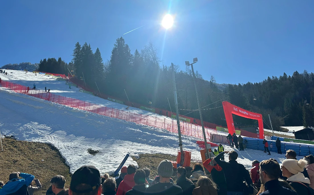 Vue d'une piste de ski sous un ciel bleu et un soleil dominant
