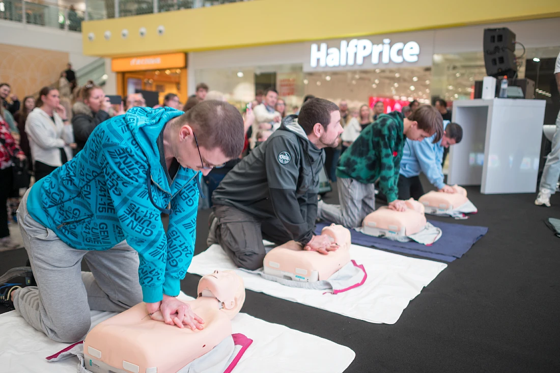 four men are seen learning about heart resuscitation using dummies