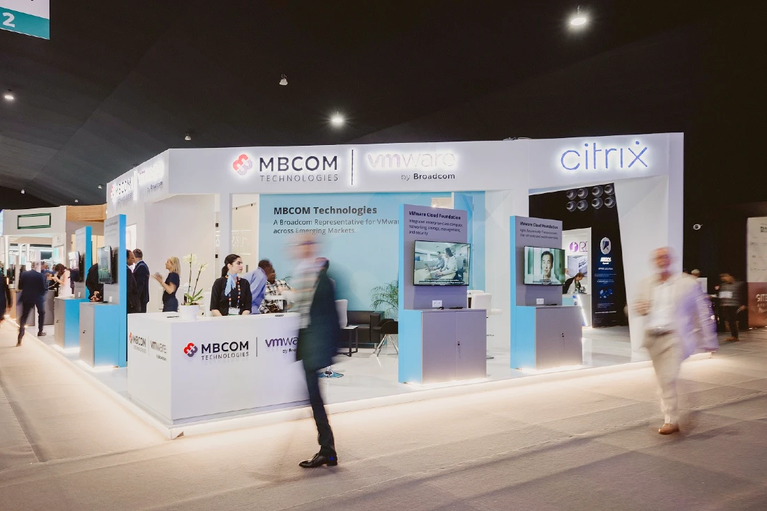 shows an exhibition stand at a hi tech event with people standing near and walking past
