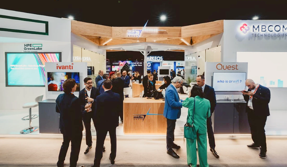 A hi tech exhibition with many people talking together in front of booths