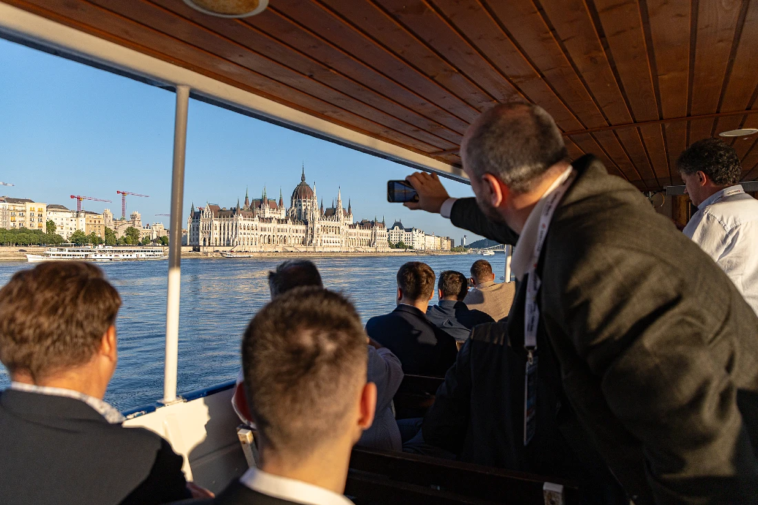 people are seen on a boat trip taking photos of an ornate and ancient building