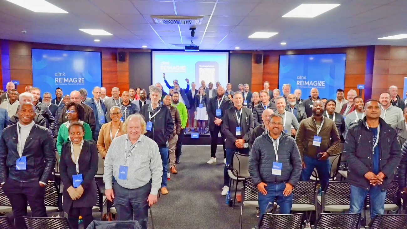 Attendees at a hi tech event are seen from the stage and are smiling and cheering