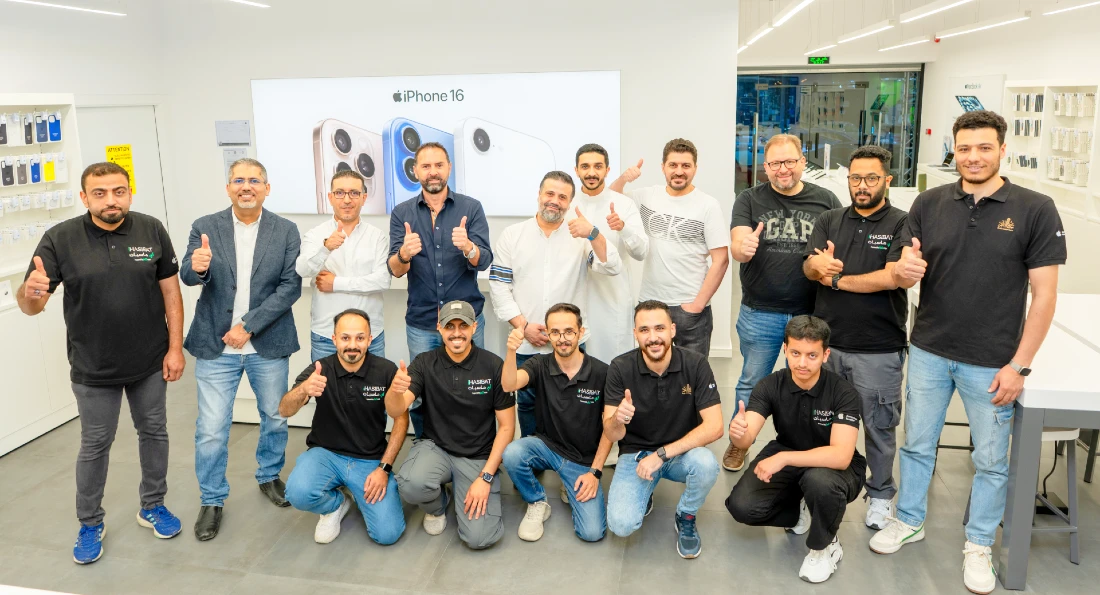 quinze hommes souriants sur une photo de groupe prise dans un magasin high-tech