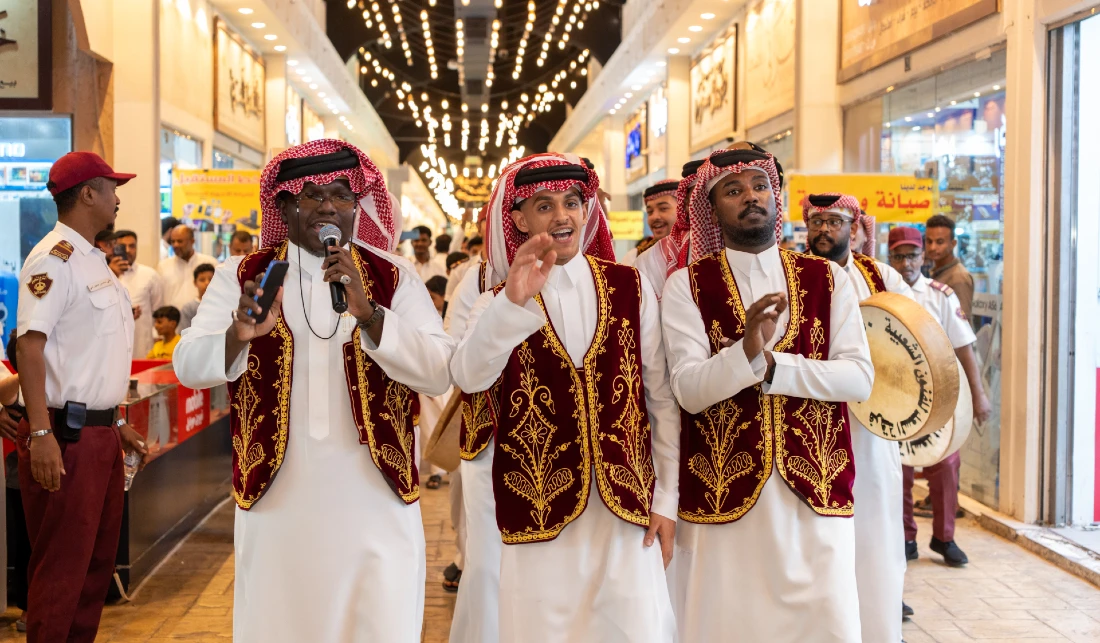 Trois membres d’un groupe de musique traditionnelle chantent dans un centre commercial.