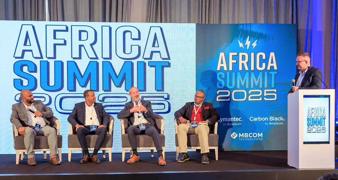 Five men on stage at an IT event are seen in a panel discussion