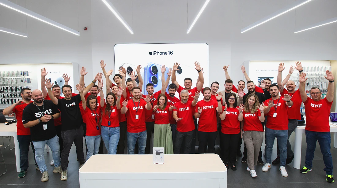 a group of people in red t-shirts are seen smiling and cheering in a group photo