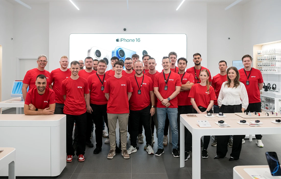 Une photo d’équipe des personnes qui travaillent dans un magasin high-tech. La plupart portent des t-shirts rouges.