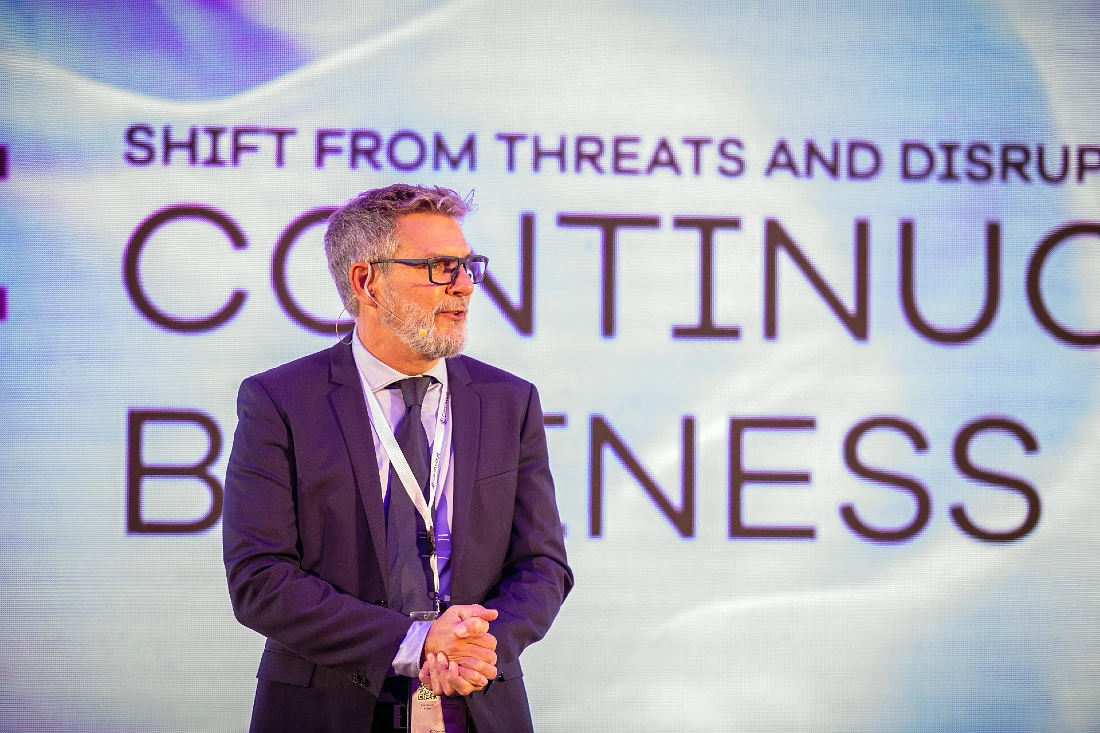 a man in a suit and tie is presenting to an audience