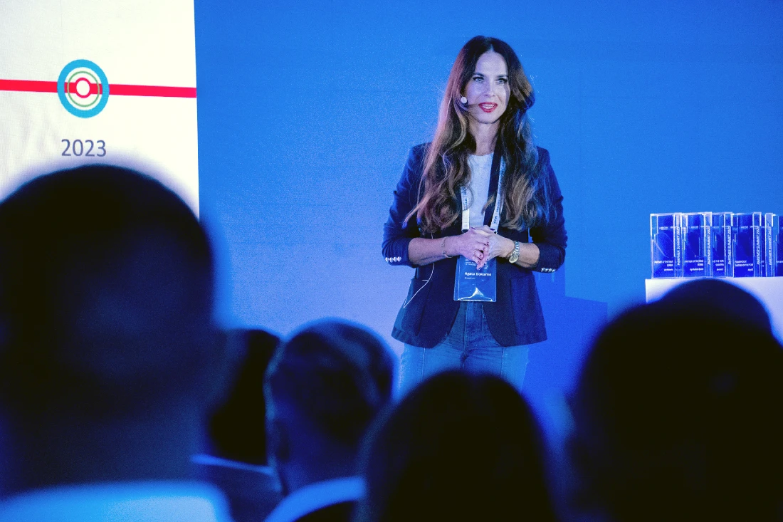 A woman presents to the audience at a hi tech event 