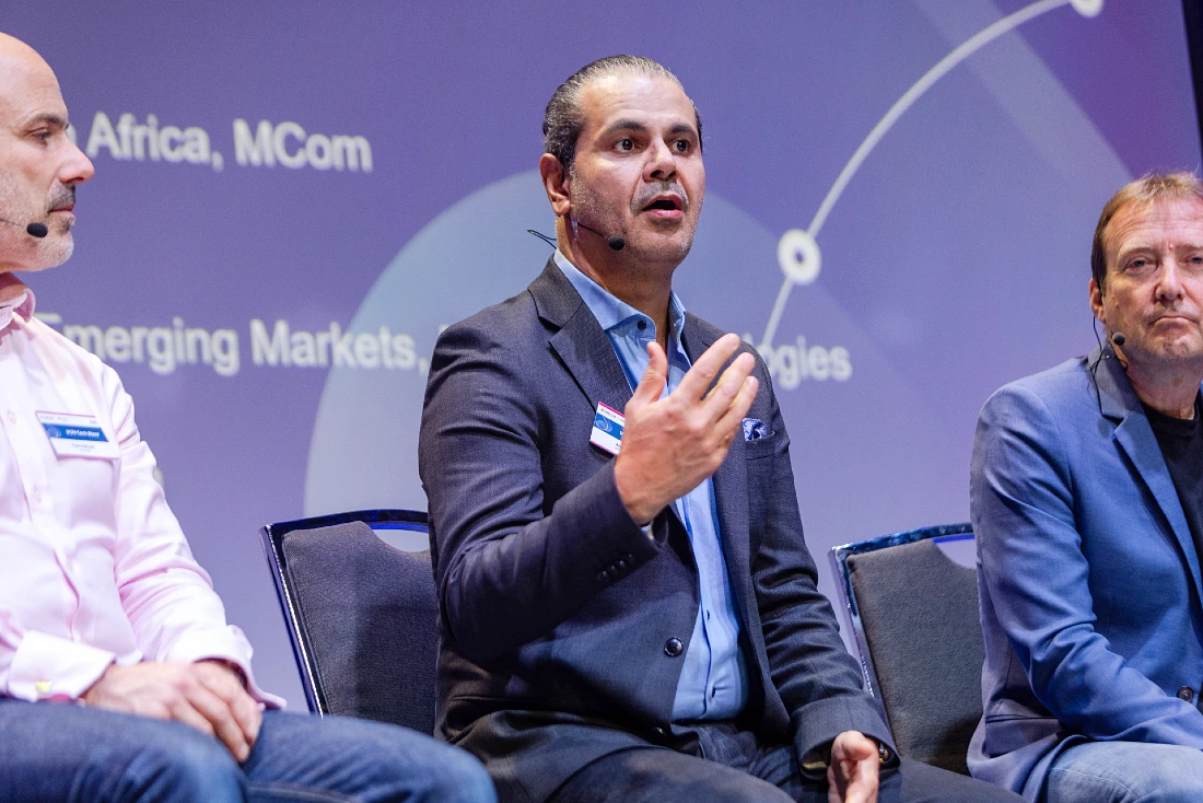 a man speaks on stage at a hi tech event panel session