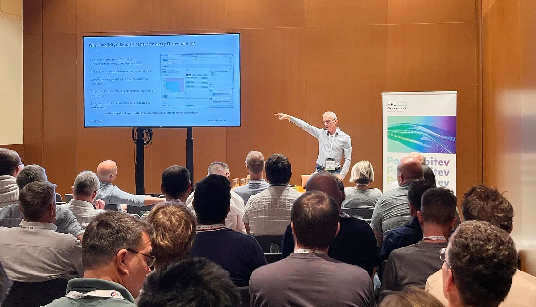 A male speaker is seen presenting to an audience at a hi tech event