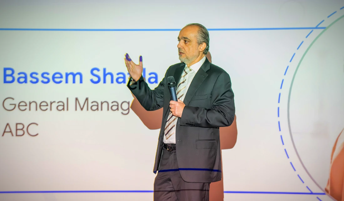 a man in a suit and tie presents to an audience at a hi tech event