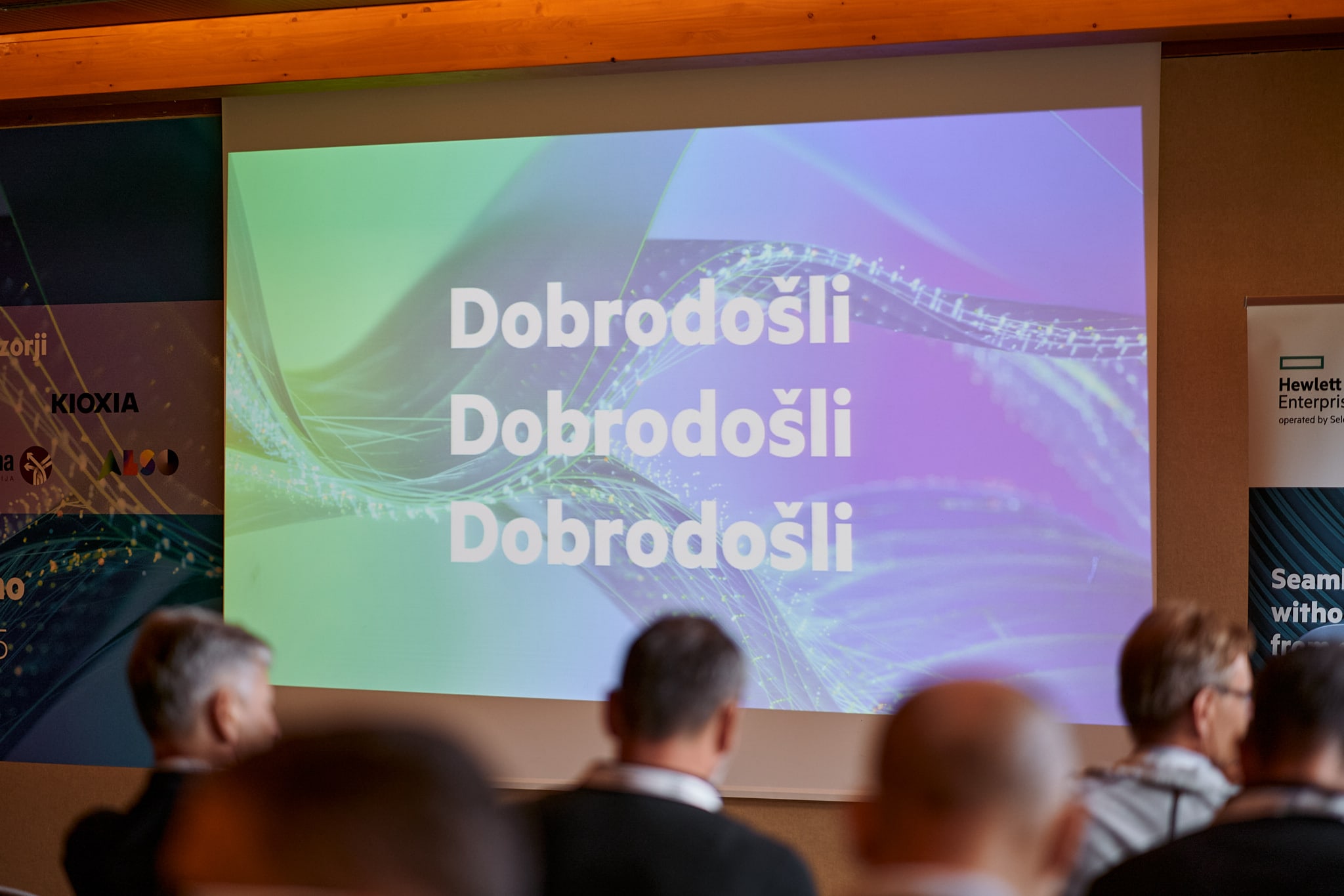 The word Welcome spelt out three times in Croatian on a presentation screen at a hi tech event