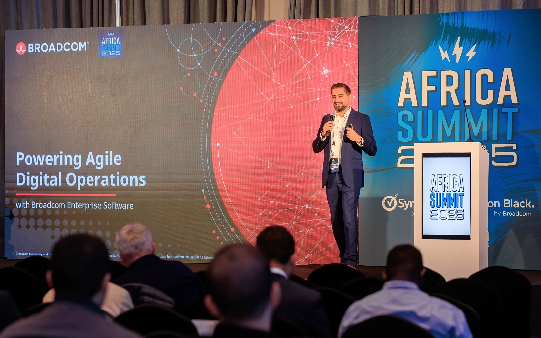 A man in a suit presents to a roomful of people at an IT event