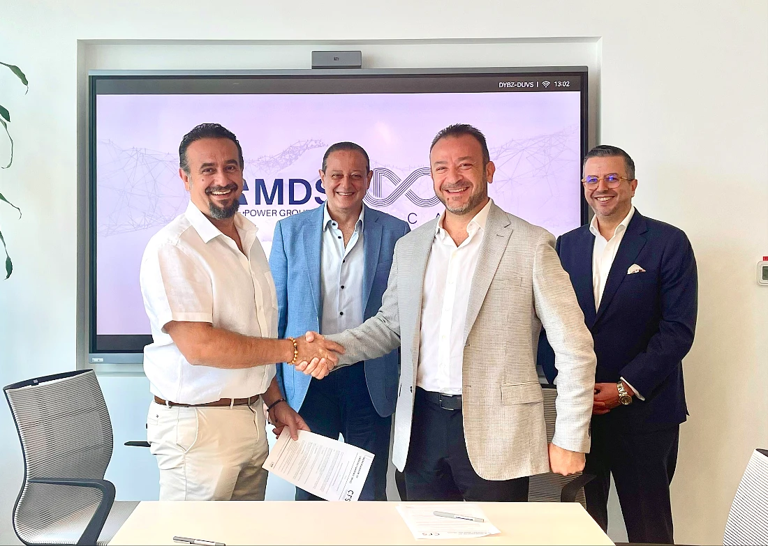 Four men in a group photo with two of them shaking hands