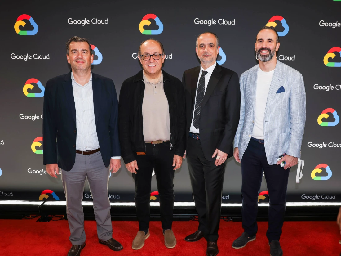 Quatre hommes souriant posent pour une photo de groupe avec un arrière-plan coloré sur lequel les mots Google Cloud sont bien visibles.
