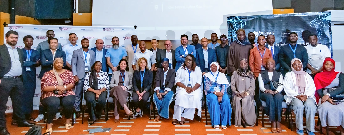 Un grand rassemblement de personnes en deux rangées est vu dans une photographie de groupe lors d'un événement high-tech.