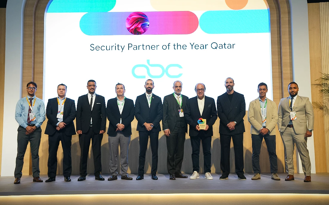 Ten people on stage at an award ceremony with a man on the right of the group holding a trophy.